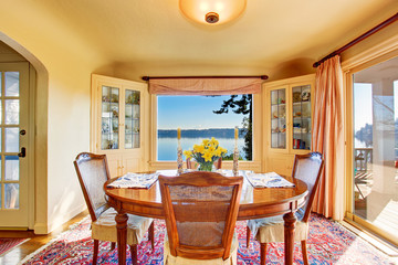 Dining room interior with wooden table set. Amazing water view.