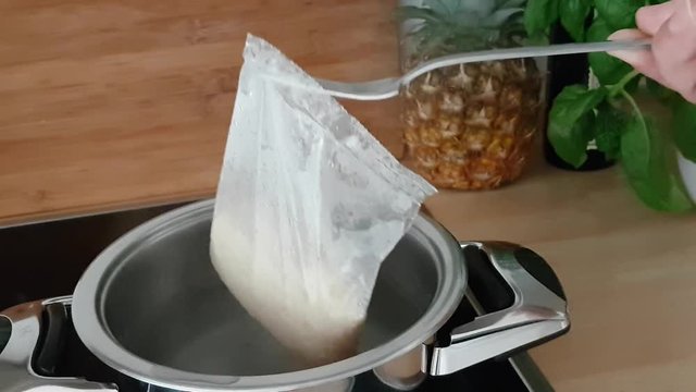 Reis kochen - Ein Reisbeutel wird  aus einem Topf genommen