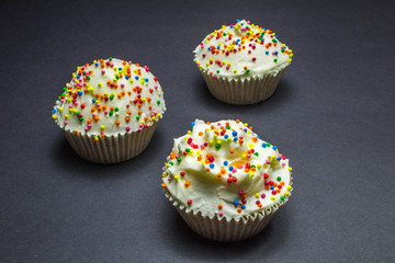 Colorful sweet cupcake with cream on black background