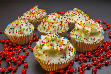 Colorful sweet cupcake with cream on black background