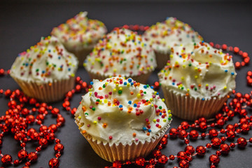 Colorful sweet cupcake with cream on black background