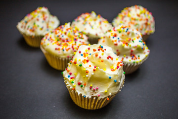 Colorful sweet cupcake with cream on black background