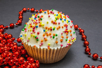 Colorful sweet cupcake with cream on black background