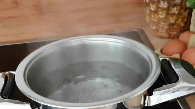 Eier kochen - Eier werden in einen Topf mit kochendem Wasser gegeben