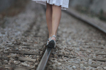 mujer caminando sobre vía de tren
