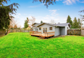 Two story house with wooden walkout deck. Fenced backyard