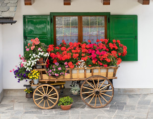 Fototapeta na wymiar Decorative wooden cart filled with flowers