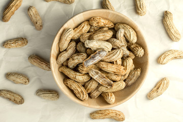 boiled peanuts in wooden cup on crumpled paper