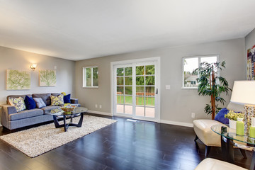 Living room with hardwood floor, beige rug and modern furniture.