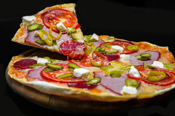 pizza with ham, pepperoni, pickles, feta