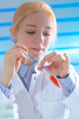 Young woman technician use pipette in laboratory