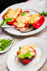 Stuffed peppers with meat and cheese on white plate
