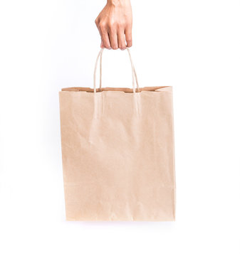 Hand Holding Brown Paper Shopping Bag On White Background