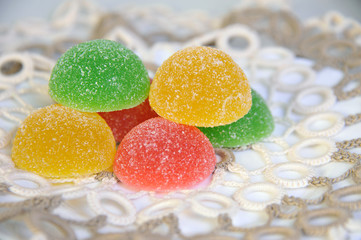 Delicious colorful marmalade lying on a beautiful cloth. Closeup.