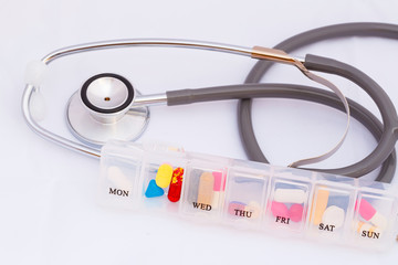Stethoscope and colorful pills on white background.Medical concept.