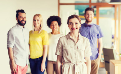 happy young woman over creative team in office