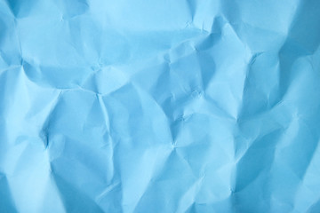 A full page of screwed up bright blue wrapping paper texture