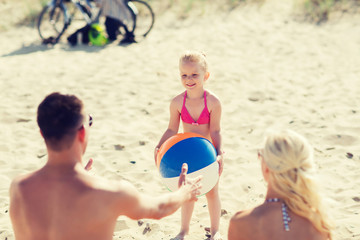 happy family playing with inflatable ball on beach