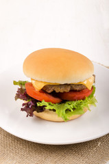 hungarian burger with salad, sliced cheese and tomato slices on