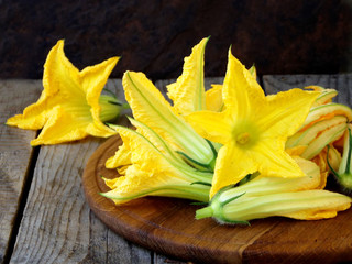 fresh, organic flowers of zucchini on wooden table. rustic style. selective focus