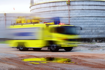 Obraz premium Fire truck, rescue and background storage tanks large at refinery oil plant .