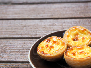 Delicious Asian Egg tart from the Hong Kong famous shop on the brown plate for healthy coffee break in the afternoon tea