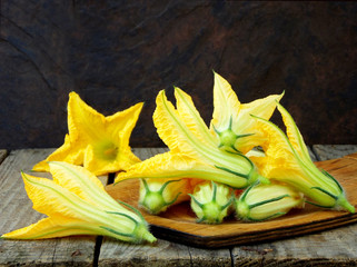 fresh, organic flowers of zucchini on wooden table. rustic style. selective focus