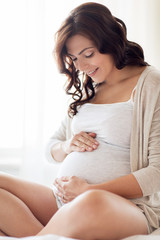 Obraz premium close up of happy pregnant woman at home