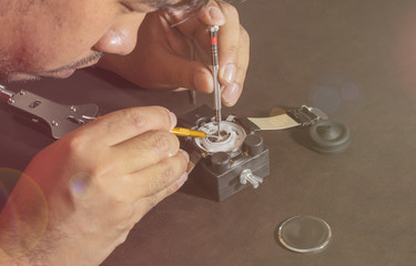 watchmaker try to fix a watch on lens fare filter