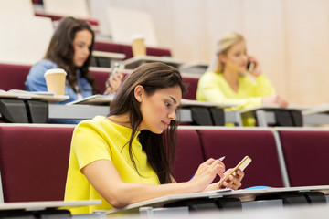 student girls with smartphones on lecture