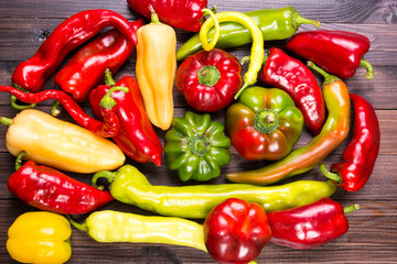 Colorful raw peppers on table - top view
