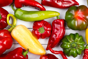 Colorful raw peppers on table - top view
