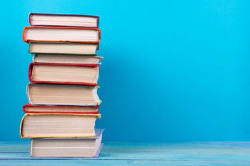 Stack of colorful books, grungy blue background, free copy space