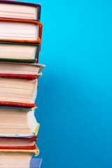 Fototapeta premium Stack of colorful books, grungy blue background, free copy space