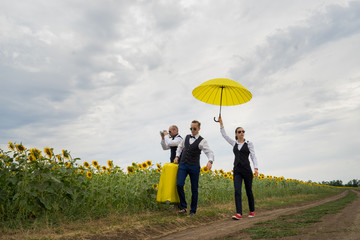 Businessmen walk along the field with sunflowers