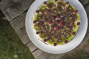 Homemade chocolate cake with raspberries and kiwi on the wooden