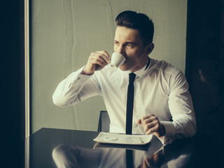 Handsome man drinks coffee