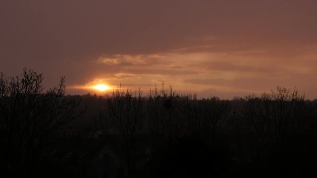 Golden sun sunset over the city on the north of Europe 4K 2160p 30fps UltraHD tilting video - Slow tilt while sun goes down behind hills 4K 3840X2160 UHD footage