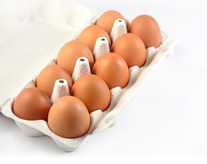Carton of fresh brown eggs on a white
