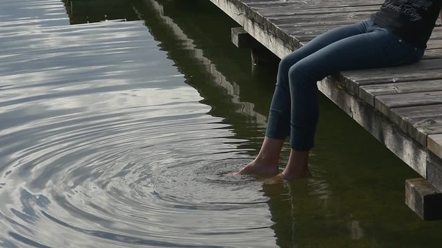 Woman feet splash water into big wave