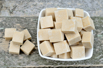 Beige sugar cubes in a ceramic bowl