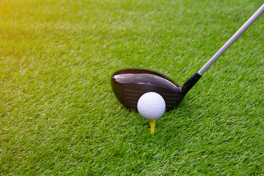 Golf ball on tee swing shot in grass green