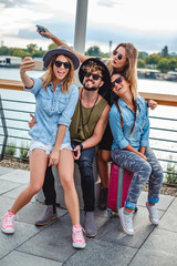 Friends taking selfie and having fun by the river