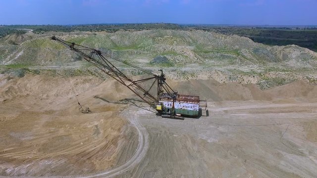 Flying over the excavator in a quarry. Production of manganese ore. aerial survey