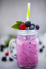 Delicious berry smoothie  made with fresh ingredients on light background.