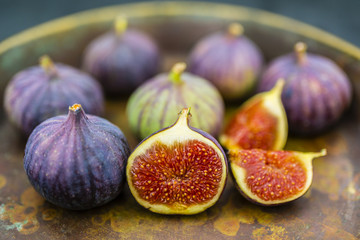 Ripe figs in the old bowl on a stone background.
