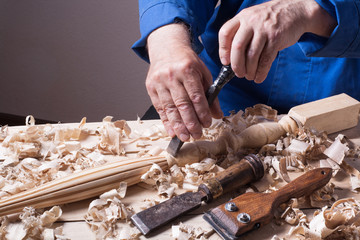 Carpenter working with plane on wooden background at Building Site. Joiner workplace.