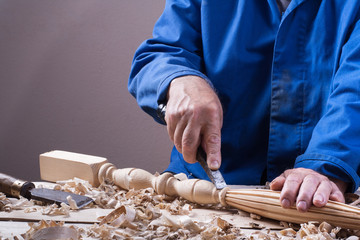 Carpenter working with plane on wooden background at Building Site. Joiner workplace.