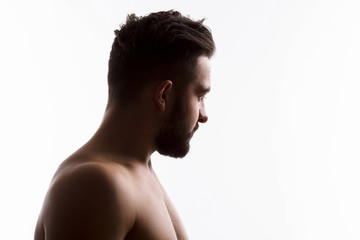 Fototapeta na wymiar Closeup profile of naked handsome hipster man looking away while posing isolated on white background in studio. Emotions concept.