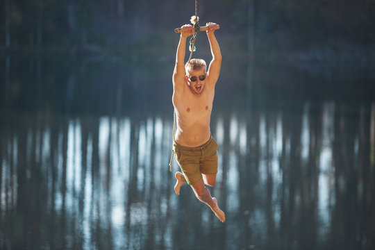 Man jumping from the top of the slope with a pope swang